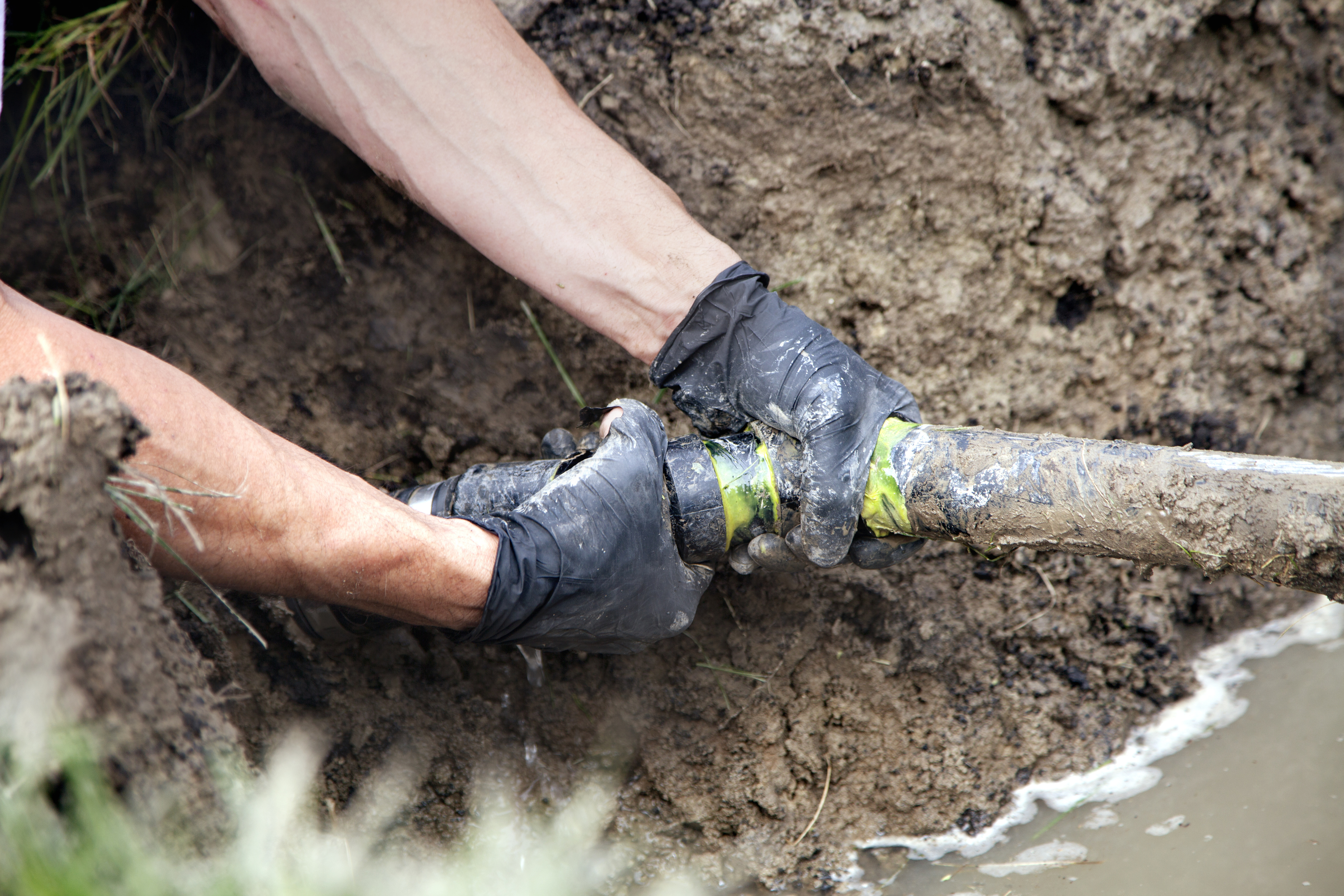 person repairing a broken pipe